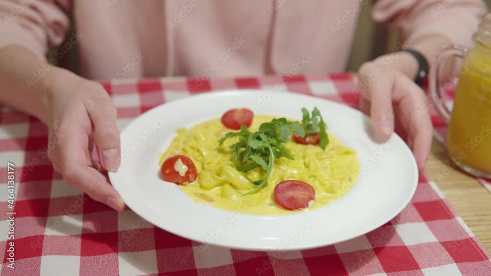 Woman is ready to eat pumpkin pasta with sauce, shrimp, cherry tomatoes and basil in the restaurant. 