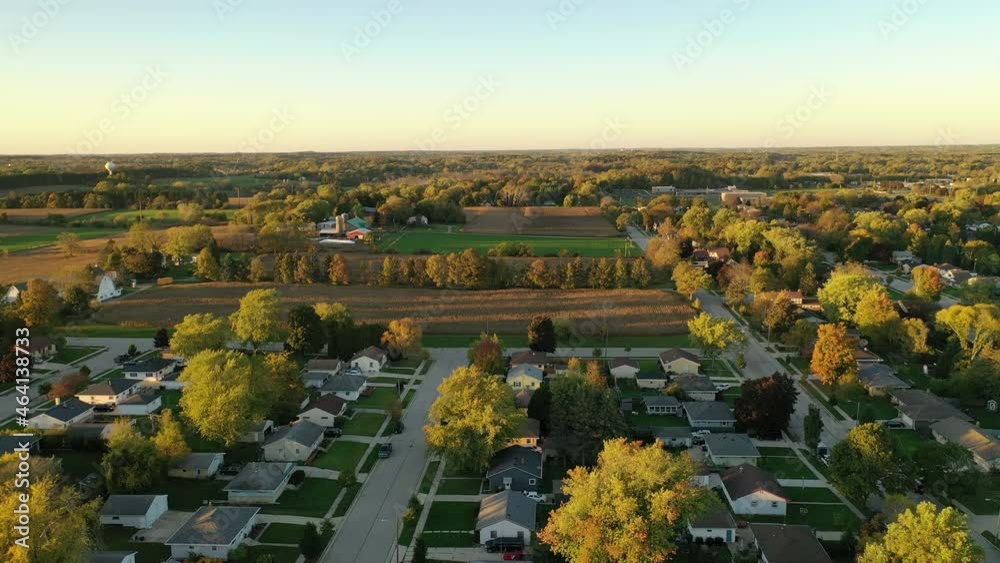 Sunset autumn rural neighborhood and farm house scene with  colorful trees, aerial drone shot. Midwest USA