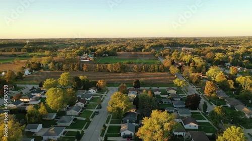 Sunset autumn rural neighborhood and farm house scene with  colorful trees, aerial drone shot. Midwest USA