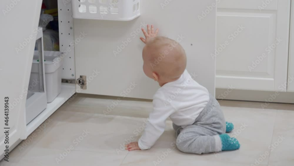 Kitchen safety for kids, baby boy exploring all around the house, toddler playing with pull out trash can under kitchen sink. High quality 4k footage Kitchen safety for kids, baby boy exploring all around the house, toddler playing with pull out trash can under kitchen sink. High quality 4k footage