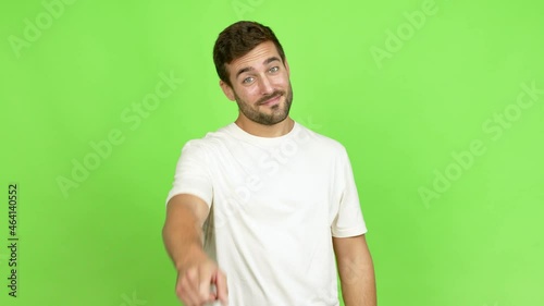 Handsome man points finger at you with a confident expression over isolated background