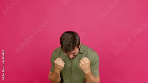 Handsome man celebrating a victory and surprised to be successful over isolated background