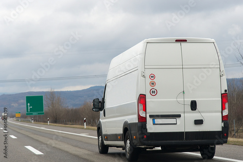 White modern delivery small shipment cargo courier van moving fast on motorway road to city urban suburb. Distribution and logistics express service. Mini bus driving on highway day. banner
