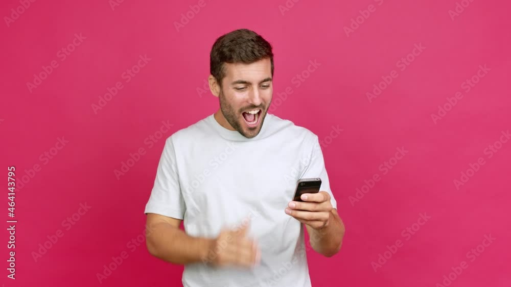 Handsome man using mobile phone and doing surprise gesture over isolated background Handsome man using mobile phone and doing surprise gesture over isolated background