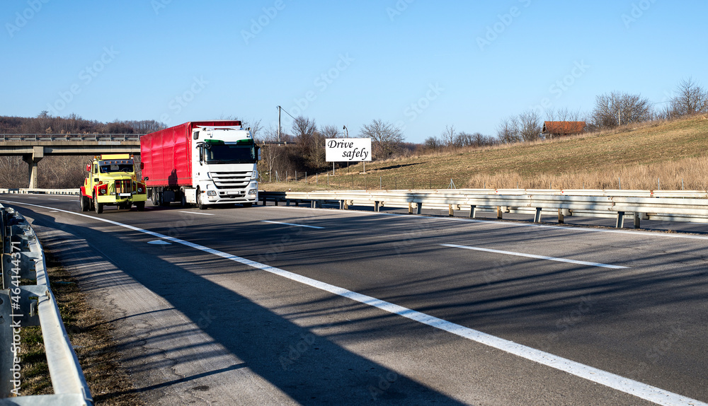Trucks driving on the asphalt highway.  Trucks driving on asphalt road in a rural landscape.