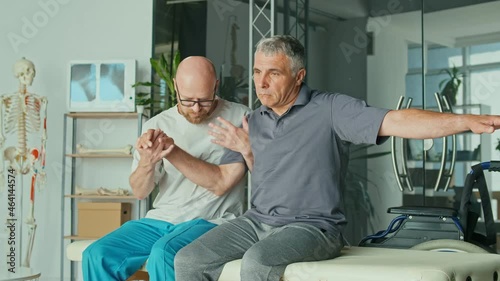 A Sick Man With a Brain Stroke Undergoes a Rehabilitation Program with a Physiotherapist in a Modern Clinic. Incapacity for Work, Limited Movement, Paralysis. Elderly Health Support Concept.
