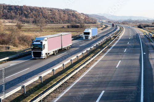 Caravan or convoy of trucks in line on a country highway.