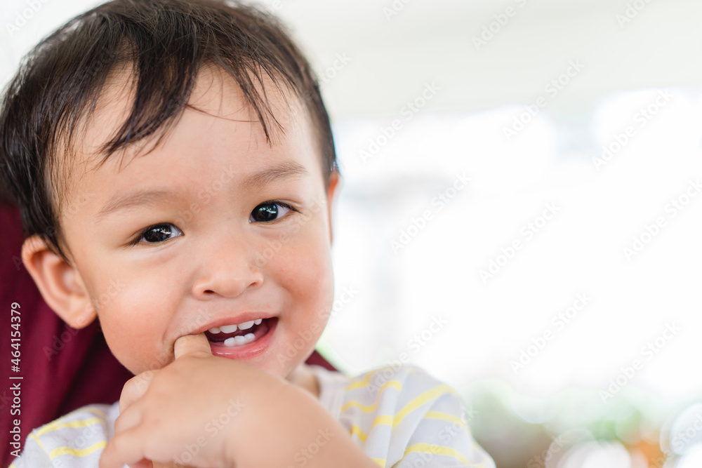 baby infant kid boy putting fingers on mouth touching first milk teeth gums pain toothache.Bad breath in baby kid.Adorable mix race baby male toddler in pain for new baby teeth.shy kid boy.dental. baby infant kid boy putting fingers on mouth touching first milk teeth gums pain toothache.Bad breath in baby kid.Adorable mix race baby male toddler in pain for new baby teeth.shy kid boy.dental.