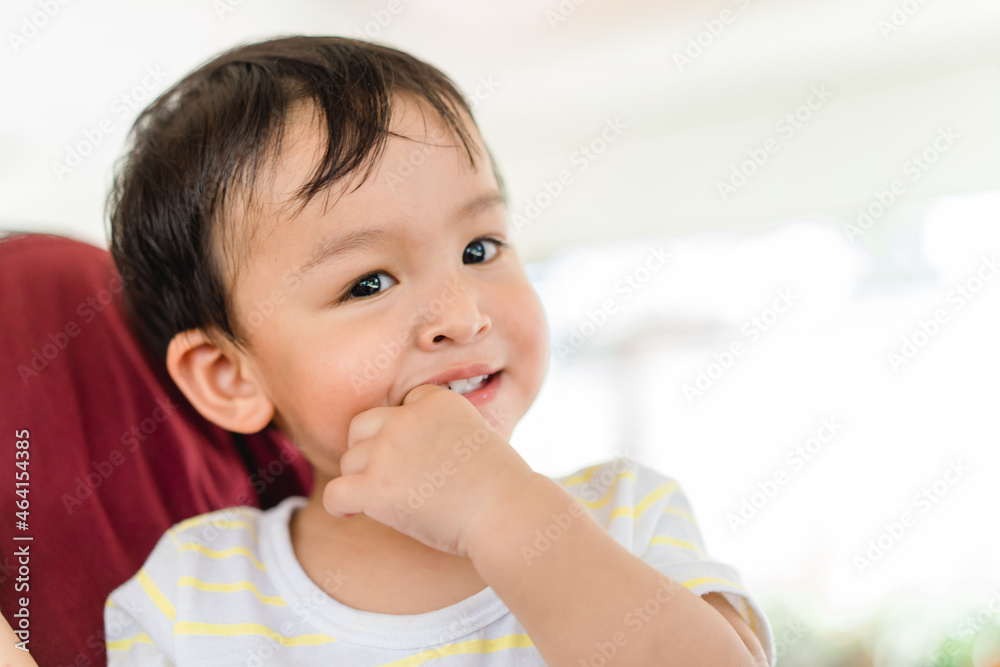 baby infant kid boy putting fingers on mouth touching first milk teeth gums pain toothache.Bad breath in baby kid.Adorable mix race baby male toddler in pain for new baby teeth.shy kid boy.dental. baby infant kid boy putting fingers on mouth touching first milk teeth gums pain toothache.Bad breath in baby kid.Adorable mix race baby male toddler in pain for new baby teeth.shy kid boy.dental.