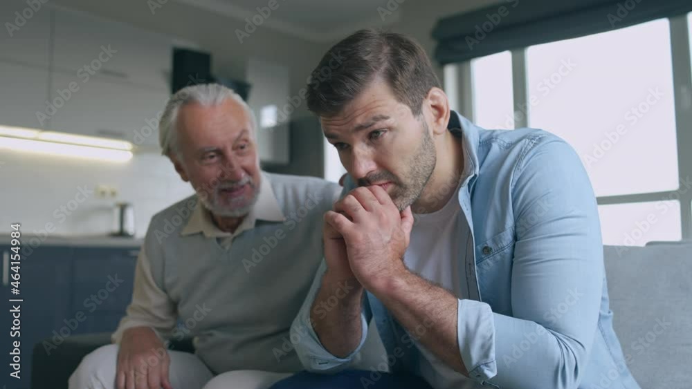 Wise senior father comforting sad son at home, giving advice, family support Wise senior father comforting sad son at home, giving advice, family support