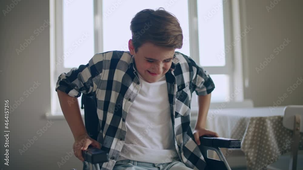 Boy with disability trying to stand up from wheelchair, willpower in recovery Boy with disability trying to stand up from wheelchair, willpower in recovery