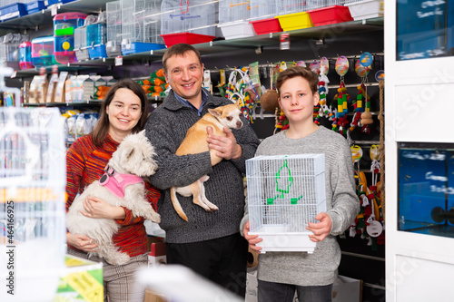 Portrait of happy family with little dog in store of pet accessories