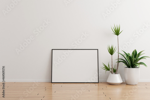 Black horizontal photo frame mockup on white wall empty room with plants on a wooden floor