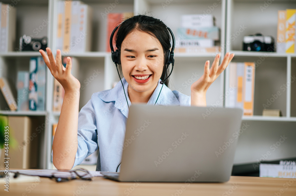 Smiling woman working at home with headset and laptop Smiling woman working at home with headset and laptop