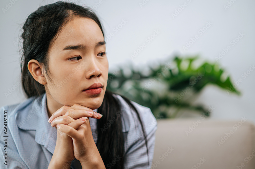 Sadness young woman sitting on sofa at home Sadness young woman sitting on sofa at home