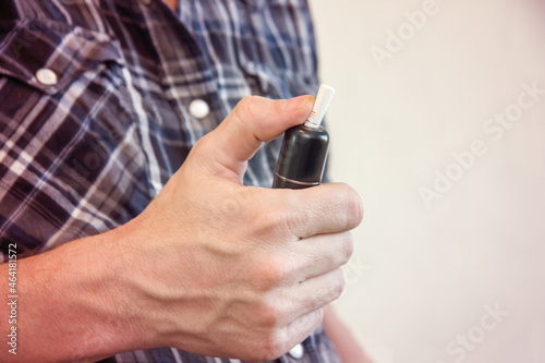 Electronic cigarette in the hands of a smoker.