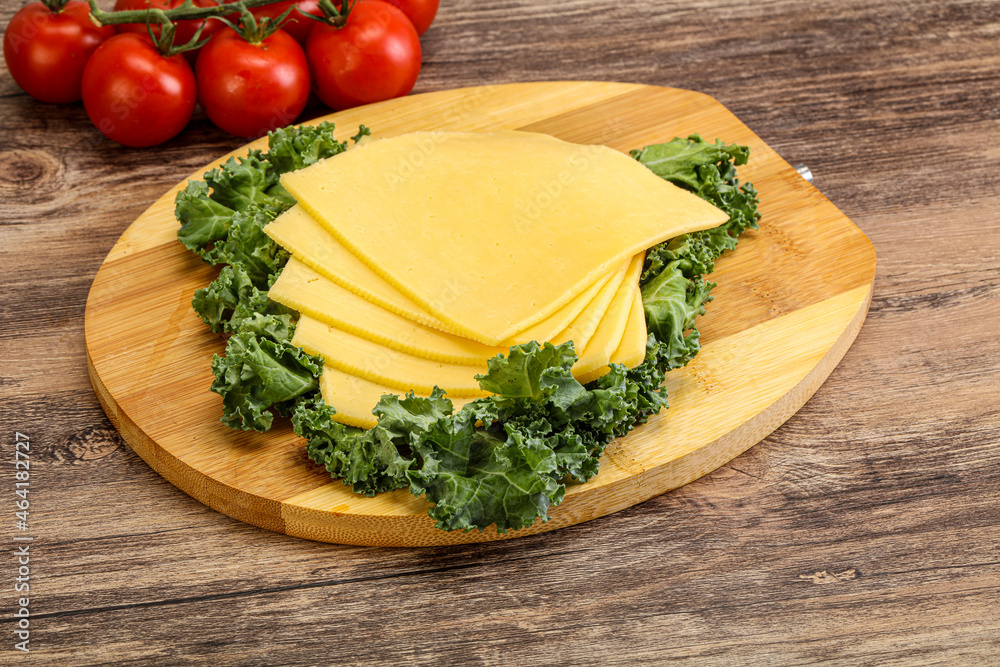 Sliced Gauda cheese over board Sliced Gauda cheese over board