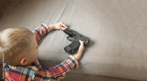 Child abuse, dysfunctional family, parenting problems,kid plays with a pistol, firearms. Gun in children's hands