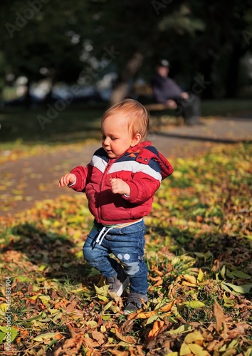 Little boy taking his first steps in the park