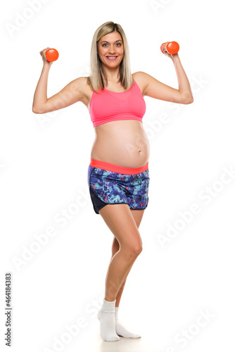 Pregnant smiling woman lifting weights