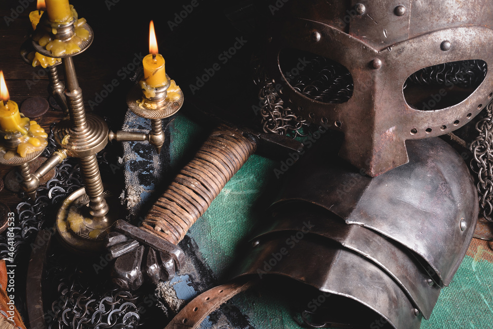 Medieval armor, sword and helmet on the table background.
