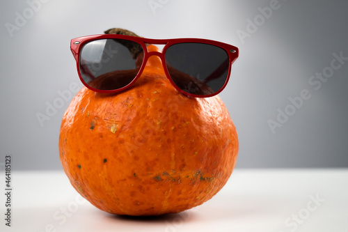 Pumpkin in sunglasses on a white background. Halloween symbol.