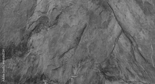 Abstract dark grey black slate background or texture. Close-up. Light gray rock backdrop.