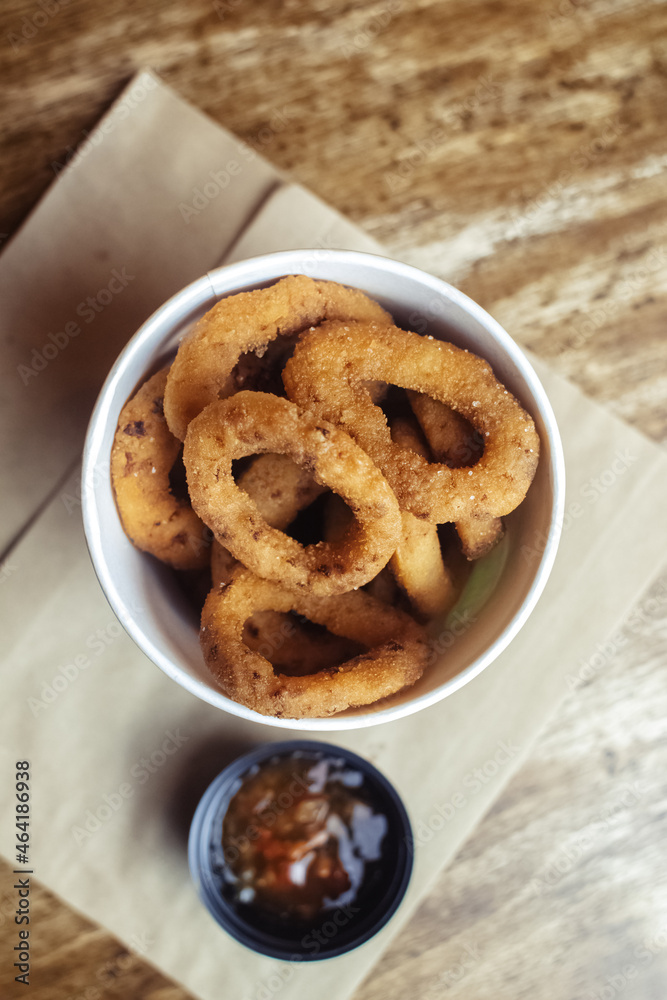 Close-up of onion rings in batter. Fried vegetables at a fast food restaurant. Vegetarian cuisine in a cafe. Meal for those who do not eat meat