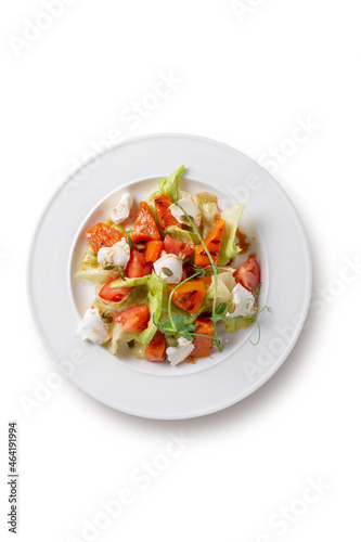 Fresh baked pumpkin salad with tomato, pumpkin seeds, Peking cabbage, feta cheese and vegetable dressing. Healthy food, vegetarian dieting, close up on isolated background