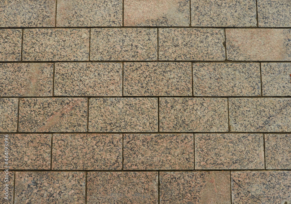 Fototapeta premium Cobblestone pavement texture background. Top view of stone road. Detail of granite sidewalk taken from above. Old street cobblestones for backdrop. Abstract vintage pavement with rough blocks.
