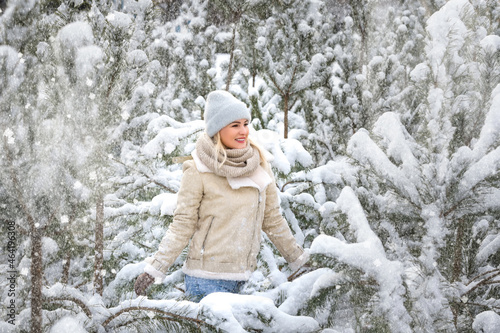 Young laughing happy Caucasian woman and pine branches in winter forest. Positive emotions, walking in snowy weather