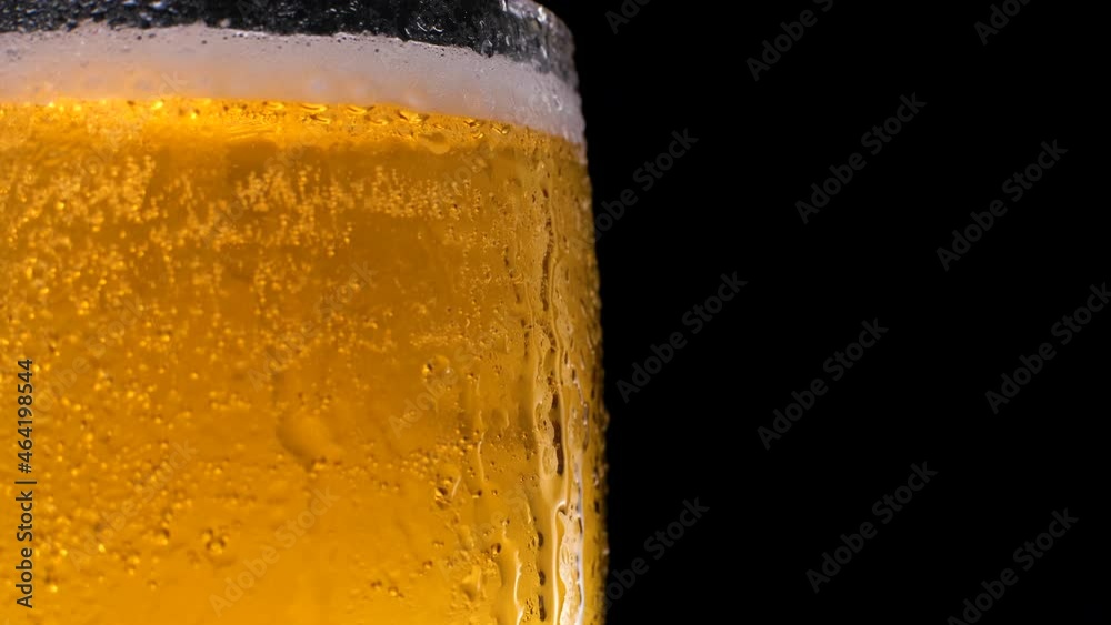 Half a beer glass with falling water drops. Cold beer in a glass with drops of water. Place for text Half a beer glass with falling water drops. Cold beer in a glass with drops of water. Place for text