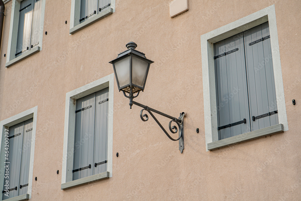Ancient street lamp detail on the facade of the building