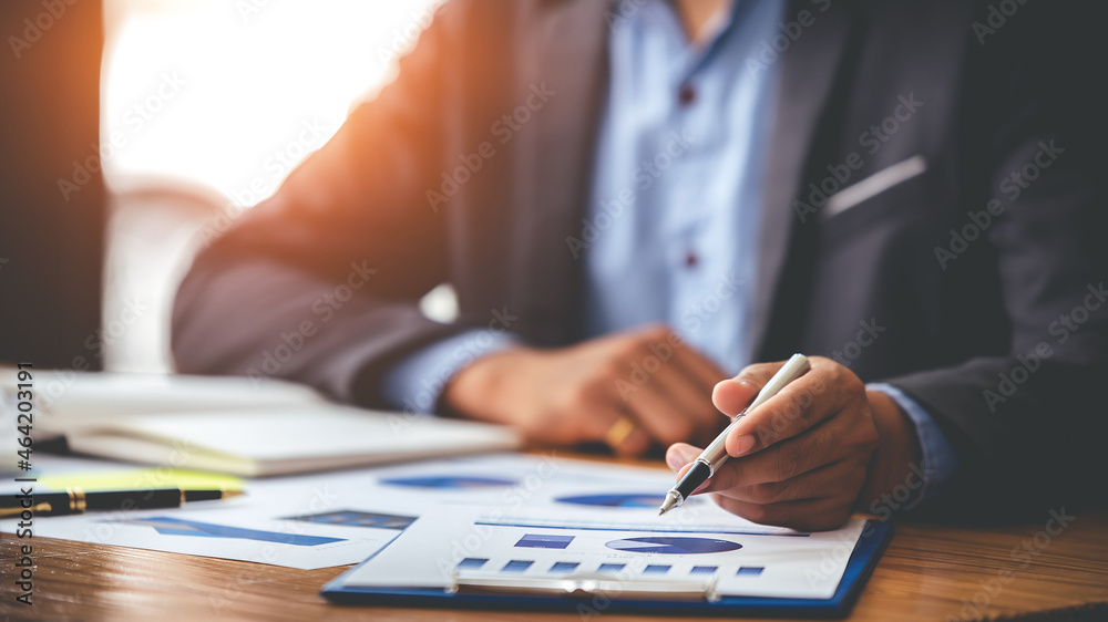Business man analyzing business price chart on the table at the conference room Business man analyzing business price chart on the table at the conference room