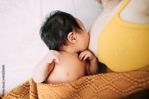 Quadro su tela Young mother is breastfeeding newborn baby