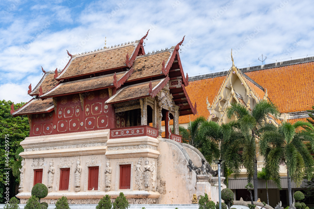 Landscape view of ancient Lanna style Hor Trai library with beautiful stucco bas-relief decoration at landmark Wat Phra Singh buddhist temple, Chiang Mai, Thailand