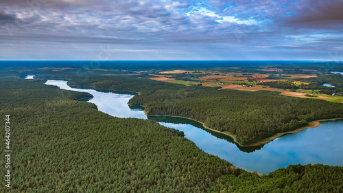 Aerial view of Ancia lake in Lithuania, shiny reflection of sky with clouds in the water of the lake