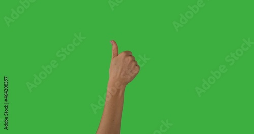 Hand of woman pointing finger and giving thumbs up gesture over green background
