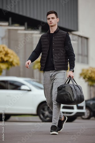 Businessman walking in a city street with black leather bag