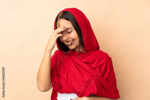 Young Indian woman isolated on beige background laughing © luismolinero