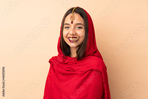 Young Indian woman isolated on beige background © luismolinero