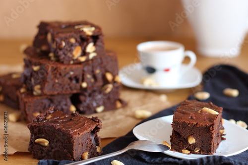 Break or snack time with a cup of coffee and chocolate brownies, served on wooden table.