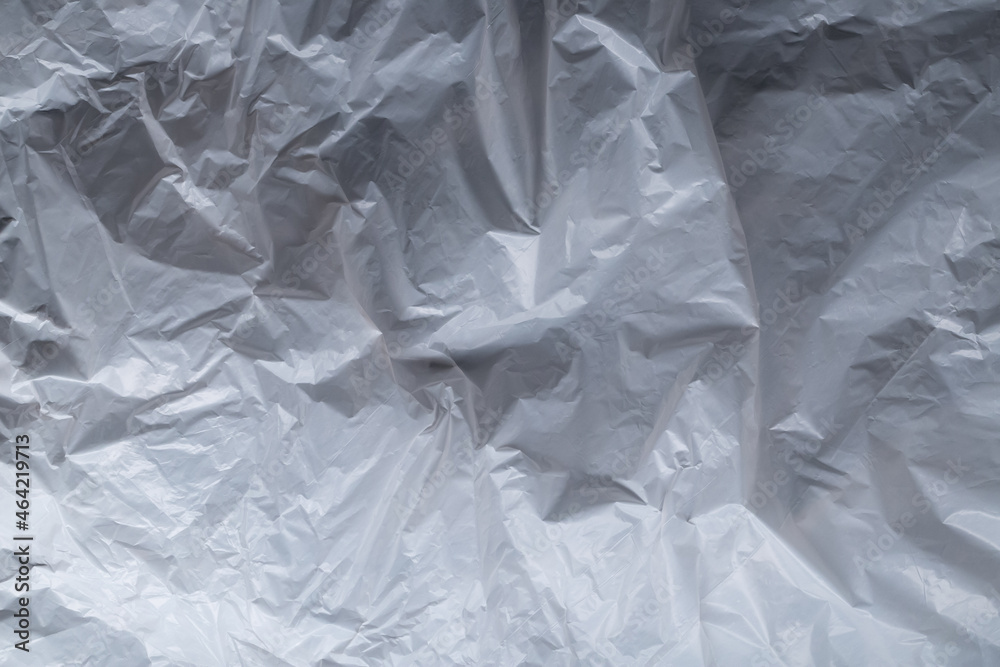 Reflecting light and shadow on creases and folds in scrunched thin white sheet of fabric or paper Reflecting light and shadow on creases and folds in scrunched thin white sheet of fabric or paper