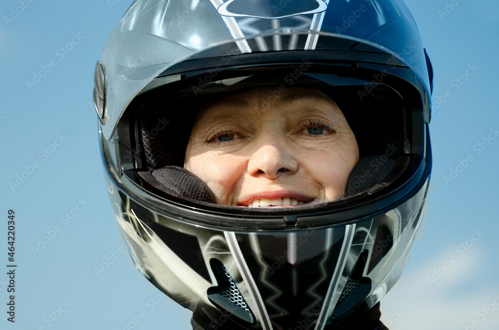 Attractive woman 60 years old in a motorcycle helmet.