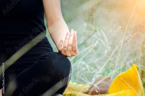 Young woman practicing yoga in the nature.female happiness. Landscape background. Blurred background, soft focus.