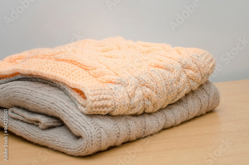 Hand-knitted warm folded clothes lie on the table. Handmade concept. photo