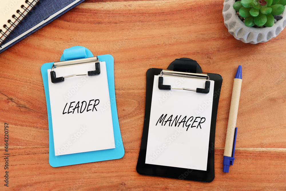 Top view image of notes with the text leader and manager. Concept of finding inspiration and motivation in management processes Top view image of notes with the text leader and manager. Concept of finding inspiration and motivation in management processes