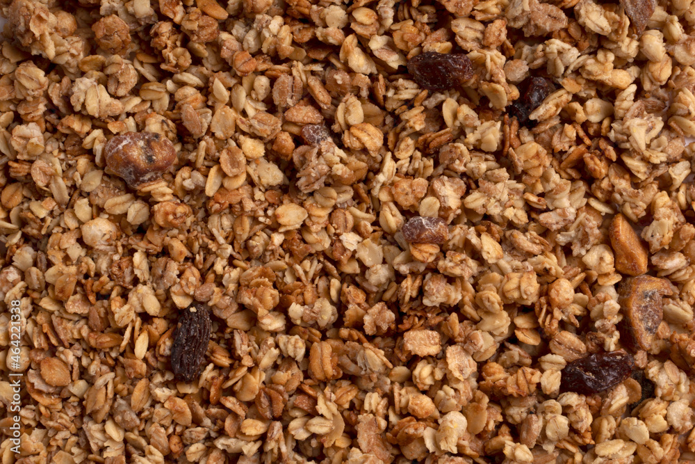 Organic granola with oats, raisins, nuts. Texture of muesli flakes as background. Top view. Blank space for text. Backplate for healthy nutrition concept. Vegetarian and vegan food for breakfast Organic granola with oats, raisins, nuts. Texture of muesli flakes as background. Top view. Blank space for text. Backplate for healthy nutrition concept. Vegetarian and vegan food for breakfast