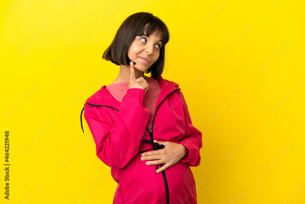 Young pregnant woman over isolated yellow background thinking an idea while looking up Young pregnant woman over isolated yellow background thinking an idea while looking up
