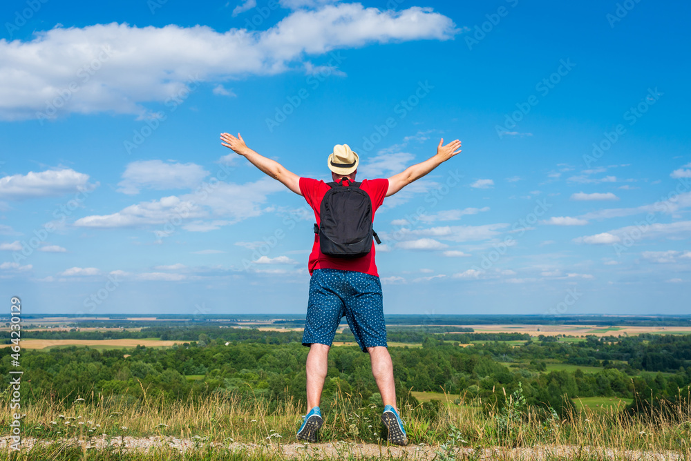 Young man admiring beautiful view of the forest landscape rear view.Young man standing alone summer day outdoors. Young man admiring beautiful view of the forest landscape rear view.Young man standing alone summer day outdoors.